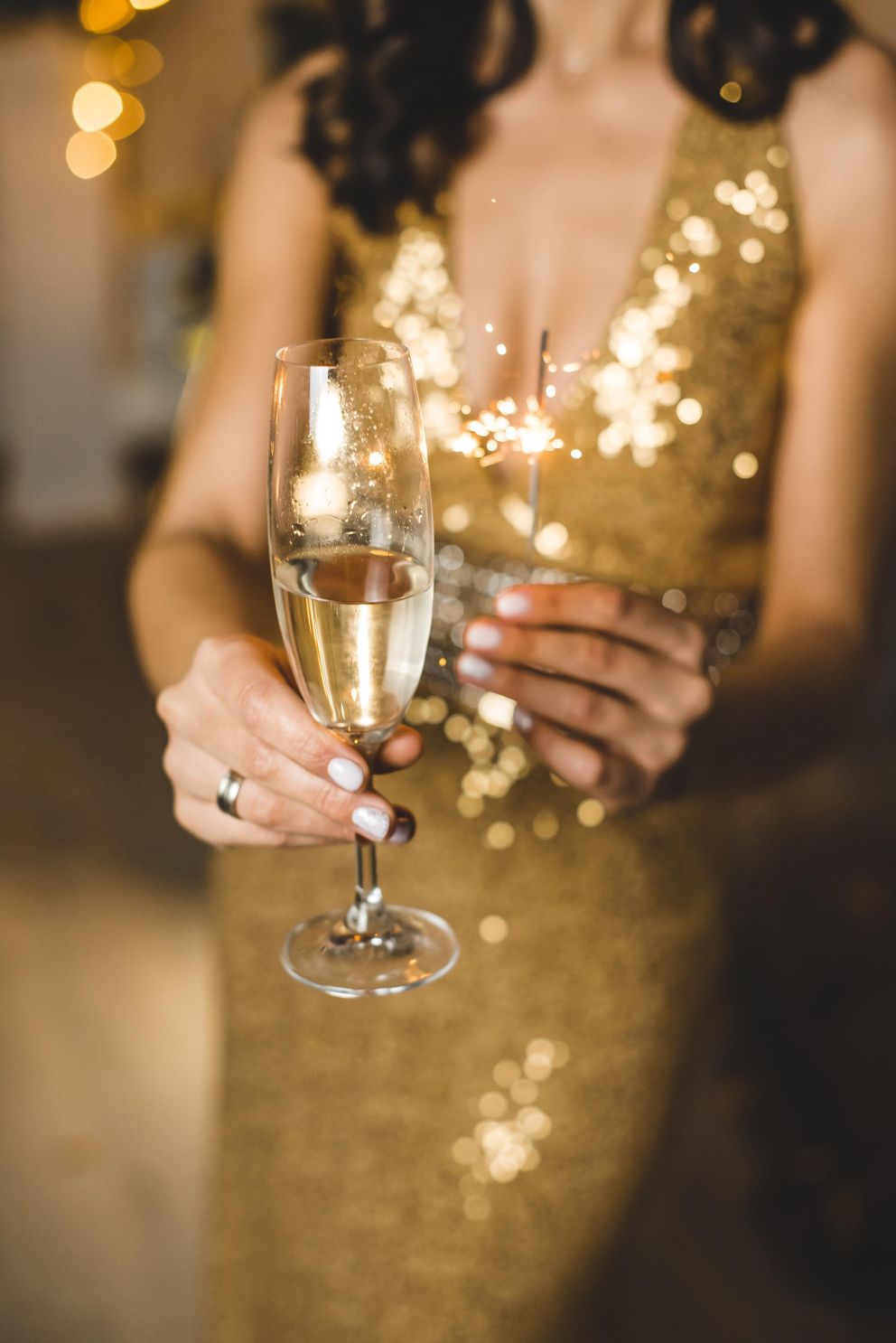 Frau in goldenen kleid hält ein champagner glas.